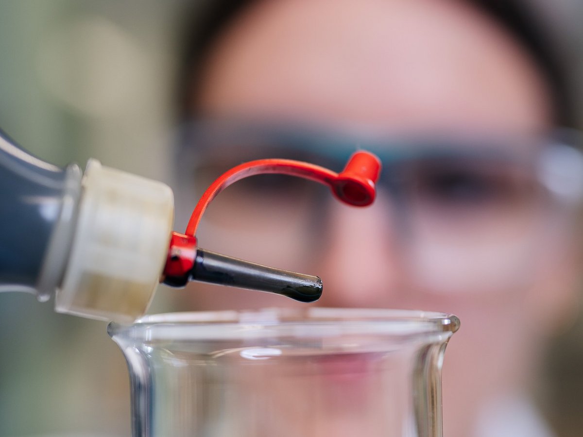 Azubi Bloggerin Tamina macht eine Ausbildung zur Chemielaborantin. Sie mischt chemische Flüssigkeiten in ein Glas.