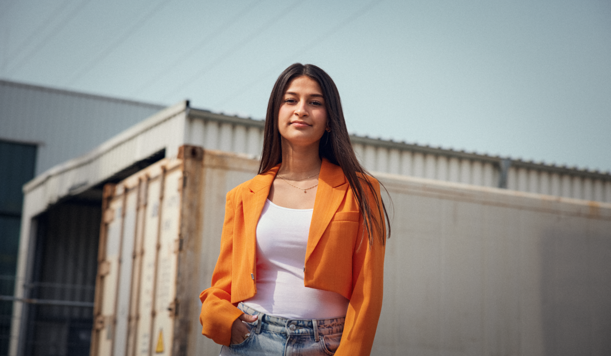 Aylin ist Botschafterin für die Ausbildung. Der IHK Azubi Kampagne könnenlernen. Aylin lang lange glatte Haare. Sie trägt einen orangenen Blazer, ein weißes Oberteil und eine Jeans.